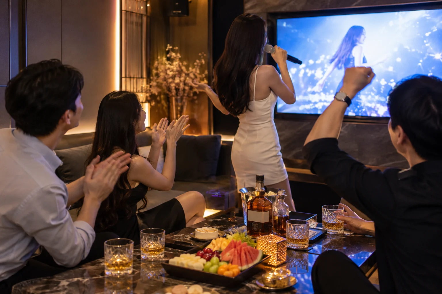 마이크로 노래하며 함께 박수 치는 일행